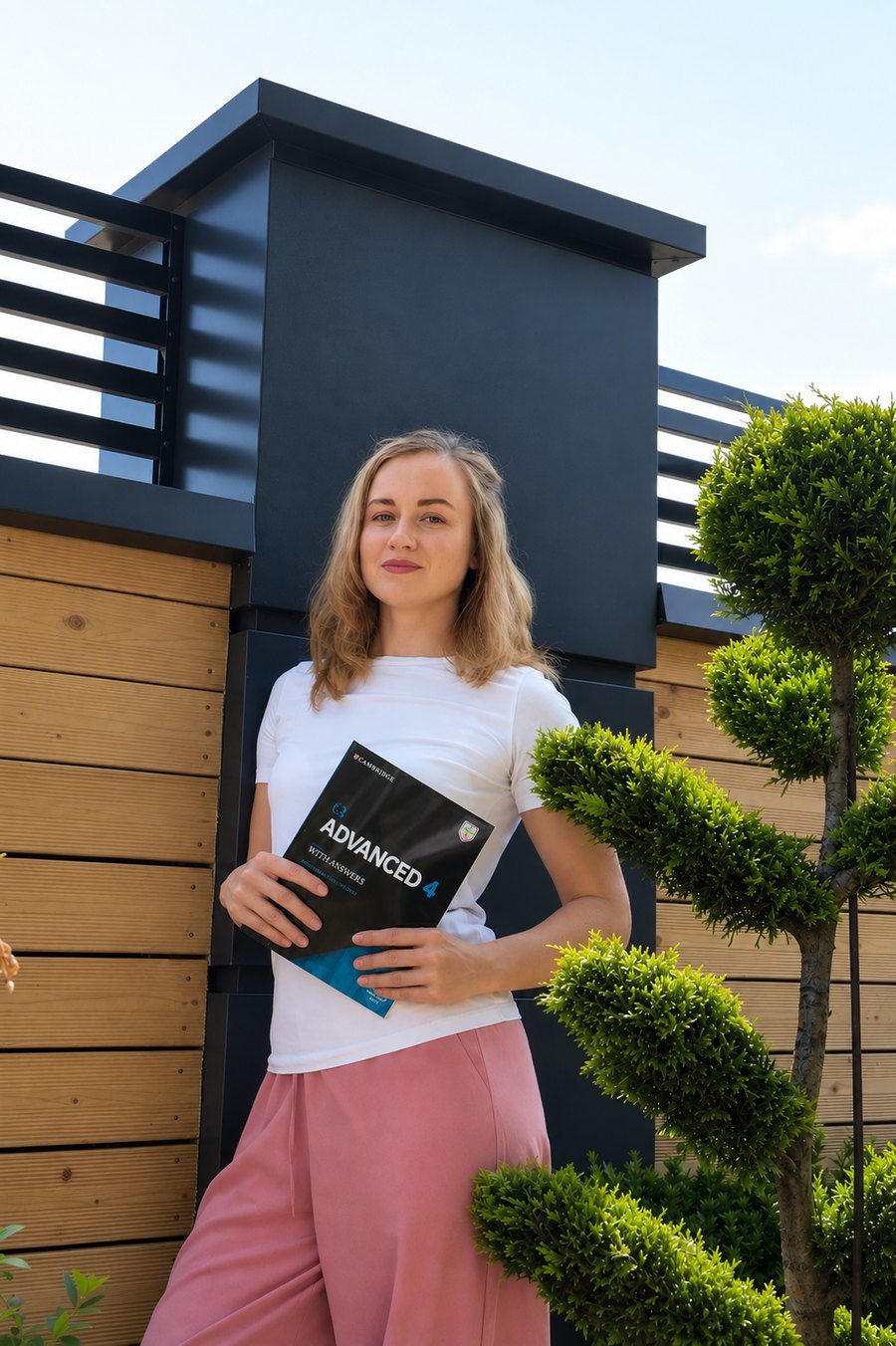 Mariia Bilous holding a Cambridge Advanced coursebook